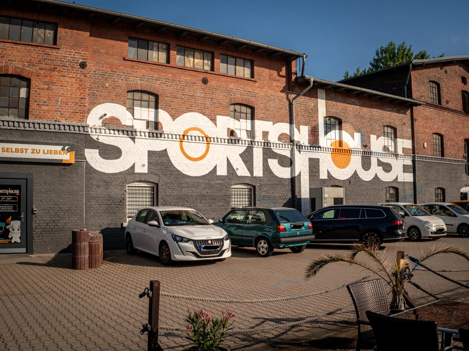 Das echte Sportshouse an der Dürener Straße 13: Backsteinfassade mit Sportshouse-Schriftzug.