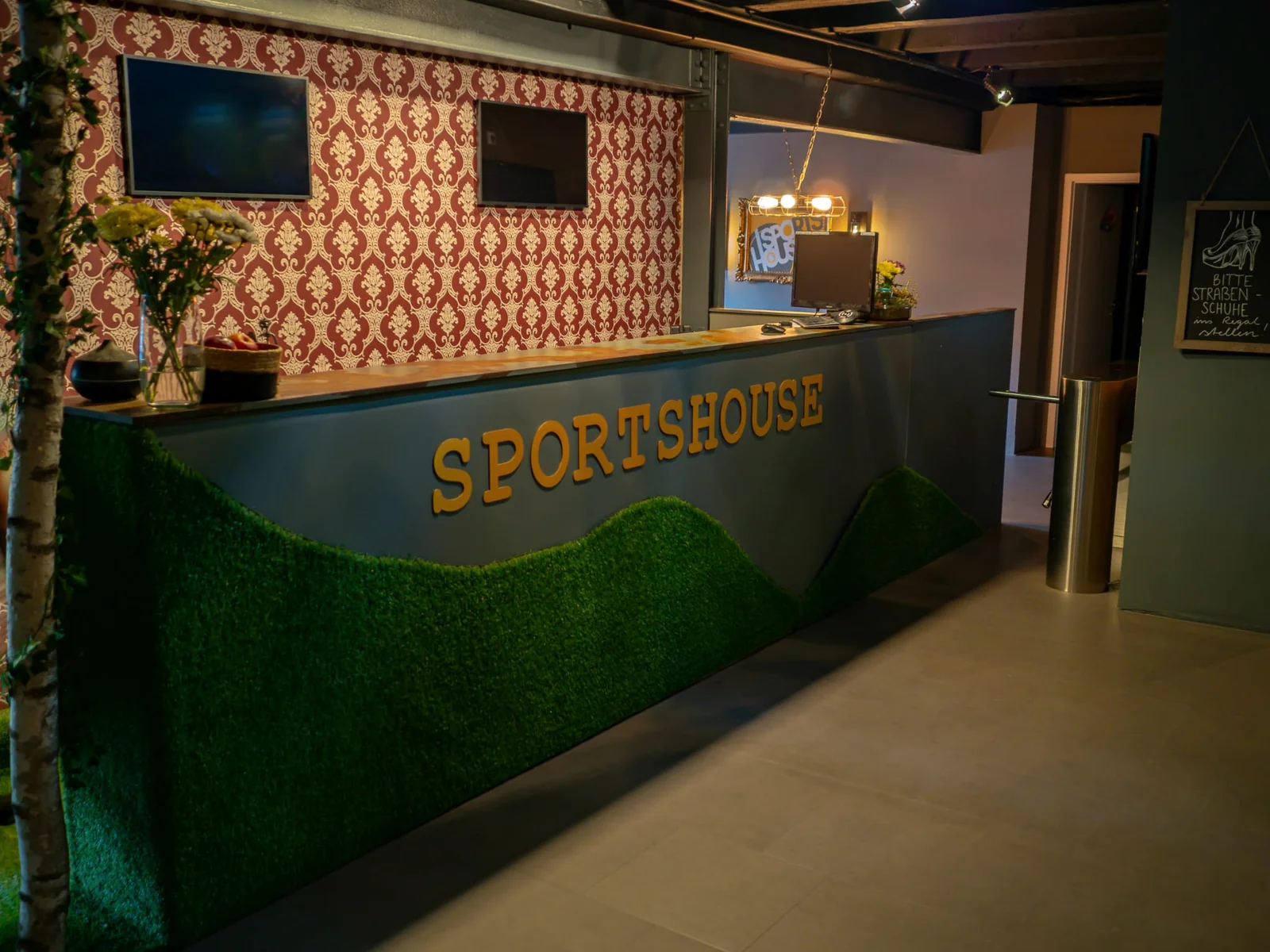 Die echte Empfangstheke des Sportshouse Bitterfeld mit grünen Akzenten.